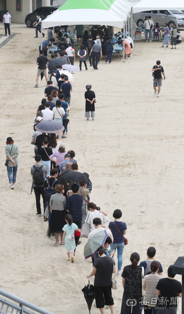 대구 이마트 월배점 코로나19 집단감염 발생으로 추가 확산 우려가 커지고 있는 가운데 지난달 30일 대구 두류공원야구장 임시선별진료소를 찾은 많은 시민들이 코로나19 검사를 받기 위해 길게 줄지어 기다리고 있다. 성일권 기자 sungig@imaeil.com