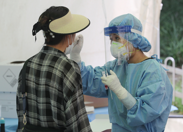 20일 대구 달서구 두류공원에 마련된 코로나19 임시선별검사소에서 의료진이 검체 채취를 하고 있다. 성일권 기자 sungig@imaeil.com