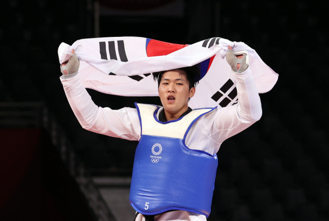 27일 일본 마쿠하리 메세홀에서 열린 도쿄올림픽 남자 태권도 80㎏ 초과급 동메달 결정전 한국 인교돈-슬로베니아 트라이코비치. 인교돈이 승리 후 태극기를 흔들고 있다. 연합뉴스