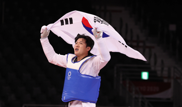 27일 일본 마쿠하리 메세홀에서 열린 도쿄올림픽 남자 태권도 80㎏ 초과급 동메달 결정전 한국 인교돈-슬로베니아 트라이코비치. 인교돈이 승리 후 태극기를 흔들고 있다. 연합뉴스