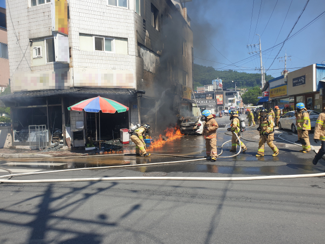 예천읍 한 상가 건물에서 발생한 불로 점포와 세워져 있던 차량 등이 불에 타 소방당국이 진압에 나서고 있다. 윤영민 기자