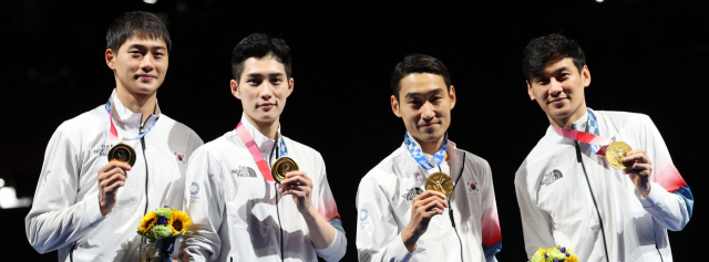 28일 일본 지바의 마쿠하리 메세에서 열린 도쿄올림픽 남자 펜싱 사브르 단체전 결승전에서 이탈리아에 승리해 금메달을 획득한 대한민국 김정환, 구본길 오상욱, 김준호 선수가 시상대에서 환호하고 있다. 연합뉴스