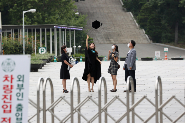 지난달 초부터 본격화한 국내 신종 코로나바이러스 감염증(코로나19) 4차 대유행 상황이 갈수록 악화하고 있는 12일 오후 서울 이화여자대학교에서 한 하계 졸업생이 가족들과 기념촬영을 하고 있다. 이화여대는 코로나19 확산 방지를 위해 정문을 폐쇄하고 소모임 촬영만 허용했다. 연합뉴스