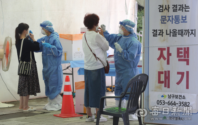 지난 31일 대구 두류공원 코로나19 임시선별검사소에서 의료진이 방문자의 검체를 채취하고 있다. 성일권 기자 sungig@imaeil.com