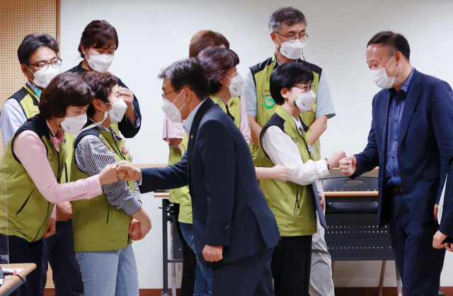 나순자 보건의료노조 위원장과 권덕철 보건복지부 장관이 2일 새벽 서울 영등포구 의료기관평가인증원에서 전국보건의료산업노동조합(보건의료노조)과 보건복지부의 13차 노정실무교섭이 타결된 뒤 양측 교섭위원들과 인사를 나누고 있다. 연합뉴스