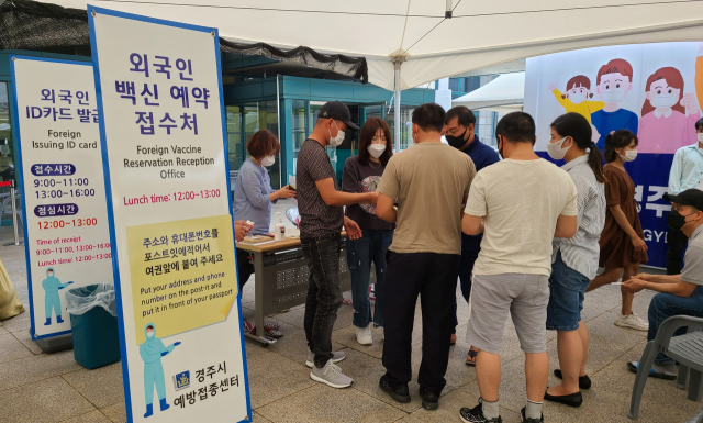 지난 2일 경주시 예방접종센터에 마련된 미등록 외국인 임시관리번호 발급 부스 앞에 외국인들이 모여 코로나19 백신 접종 예약을 준비하고 있다. 김도훈 기자