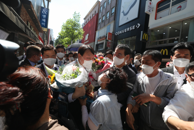 국민의힘 대권주자인 윤석열 전 검찰총장이 11일 오후 대구 중구 동성로를 찾아 지지자로부터 꽃을 받고 있다. 안성완 기자 asw0727@imaeil.com