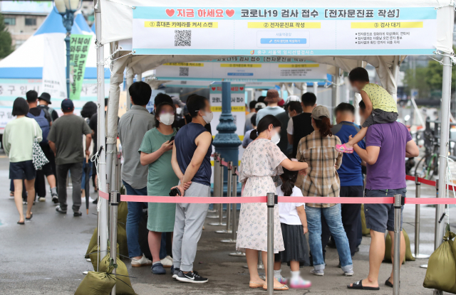 국내 신종 코로나바이러스 감염증(코로나19)이 수도권을 중심으로 다시 확산하며 신규 확진자 수가 1천700명대 초반을 나타낸 22일 서울 중구 서울역 광장 임시 선별검사소에서 귀경객들이 코로나19 검사를 기다리고 있다. 연합뉴스