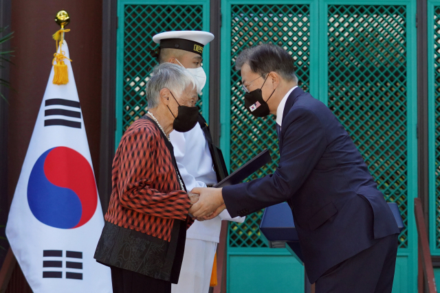 문재인 대통령이 22일(현지시각) 미국 하와이대 한국학 연구소에서 열린 독립유공자 훈장 추서식에서 독립유공자 김노디 지사 후손에게 애국장을 수여한 뒤 박수치고 있다. 연합뉴스