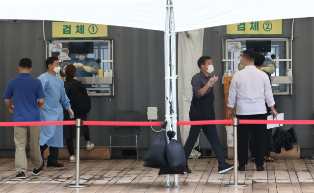 국내 신종 코로나바이러스 감염증(코로나19) 신규 확진자가 1천953명을 기록한 9일 오전 서울시청 앞 서울광장 임시선별검사소를 찾은 시민들이 검사를 받고 있다. 연합뉴스