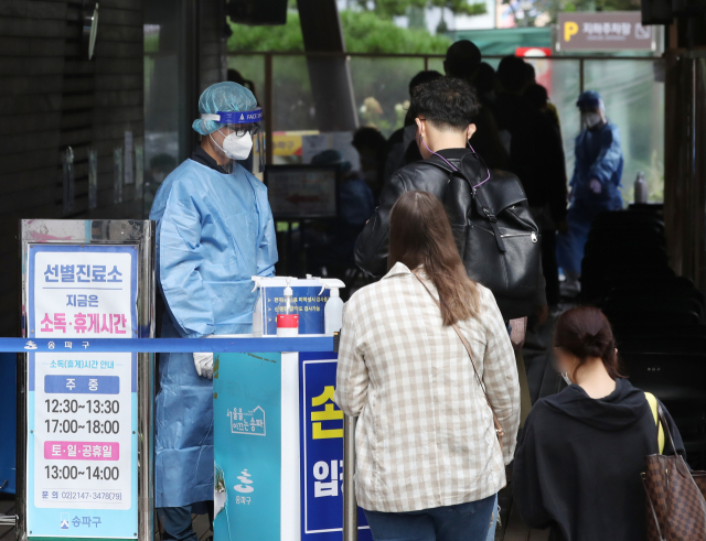 12일 서울 송파구 보건소 선별진료소에서 시민들이 신종 코로나바이러스 감염증(코로나19) 검사를 기다리고 있다. 중앙방역대책본부는 이날 0시 기준 코로나19 신규 확진자가 1천347명 늘어 누적 33만4천163명이라고 밝혔다. 신규 확진자 수는 전날보다 50명 늘면서 나흘째 1천명대를 유지했다. 연합뉴스