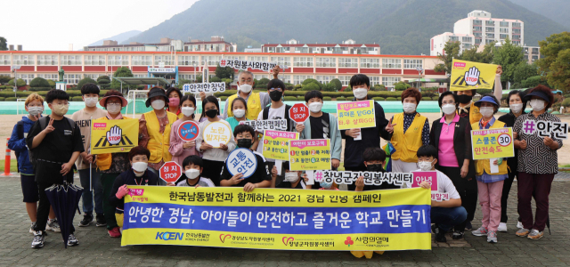 영산초등학교 앞에서 봉사자들과 학생들이 노란발자국 캠페인 실시 기념 사진을 촬영하고 있다. 창녕군 제공