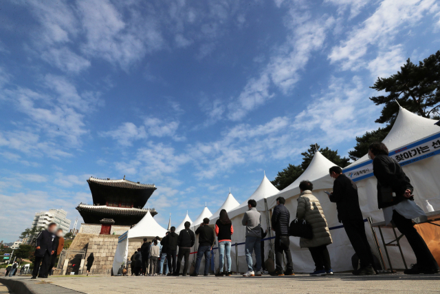 18일 오전 서울 종로구 흥인지문 옆에 설치된 찾아가는 선별검사소에서 코로나19 집단감염이 발생한 동대문 인근 시장 종사자들이 검사를 받기 위해 대기하고 있다. 연합뉴스