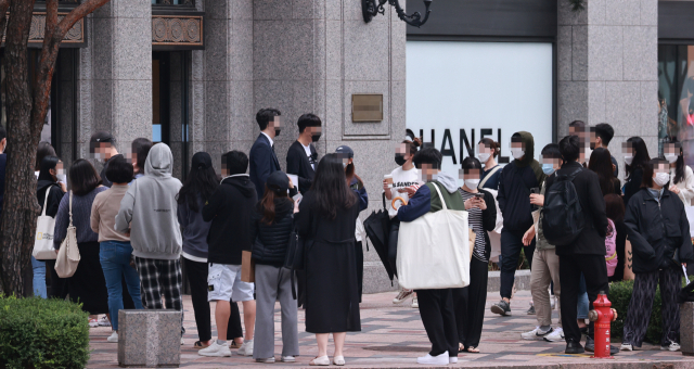 한국인의 1인당 명품 소비액이 세계에서 가장 많았다는 외신 보도가 나왔다. 한국 가구의 순자산이 부동산 가격 상승에 힘입어 11% 증가한 데다 외모를 중시하는 풍조가 명품 수요를 늘렸다는 분석이 나온다. 사진은 지난해 서울 시내 한 백화점 명품관 앞에서 고객들이 개점 시간을 앞두고 입장하기 위해 대기하는 모습. 연합뉴스