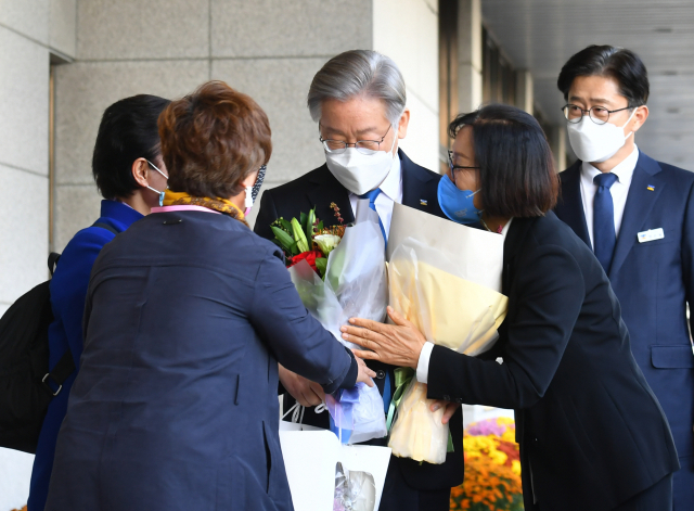 더불어민주당 대선 후보인 이재명 경기도지사가 25일 오후 경기도 수원시 경기도의회를 방문하며 지지자들에게 꽃다발을 받고 있다. 이 후보는 이날 경기도청에서 기자회견을 열어 경기도지사직을 사퇴했다. 연합뉴스