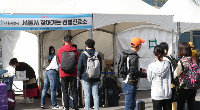 서울시 강서구 김포공항에 마련된 코로나19 임시선별진료소에서 여행을 다녀온 관광객들이 코로나 검사를 받기 위해 줄을 서 있다. 연합뉴스