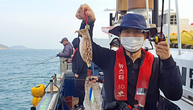 경기도 일산에서 온 김진수씨가 잡아올린 갑오징어를 들어보이고 있다.