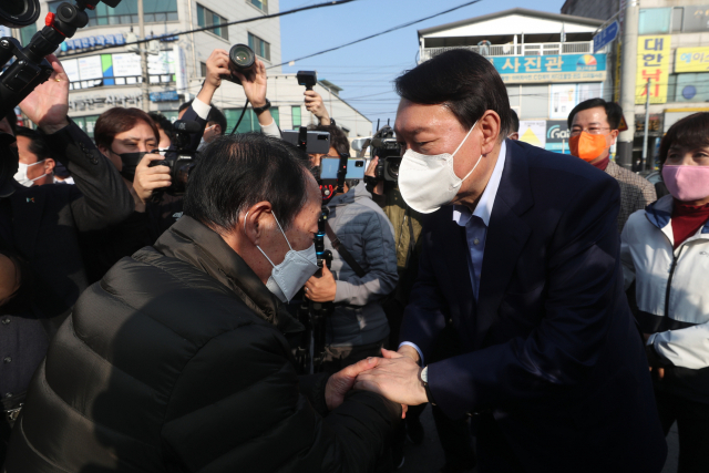 국민의힘 윤석열 대선 경선 후보(오른쪽)가 4일 경기도 연천군 전곡읍 전곡시장을 방문해 주민과 인사를 나누고 있다. 연합뉴스