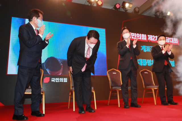 국민의힘 윤석열 대선후보가 5일 서울 용산구 효창동 백범김구기념관에서 열린 제2차 전당대회에서 개표결과 발표 후 축하를 받고 있다. 연합뉴스