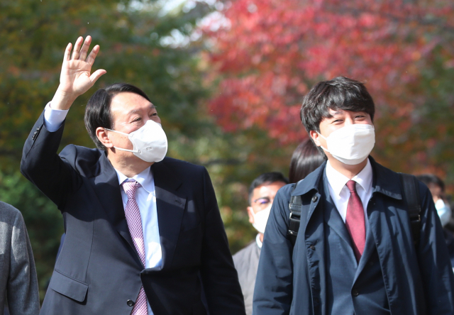 국민의힘 윤석열 대선 후보가 6일 오후 이준석 대표와 오찬을 위해 서울 마포구 염리동 한 식당으로 이동하며 시민들에게 손을 들어 인사하고 있다. 연합뉴스