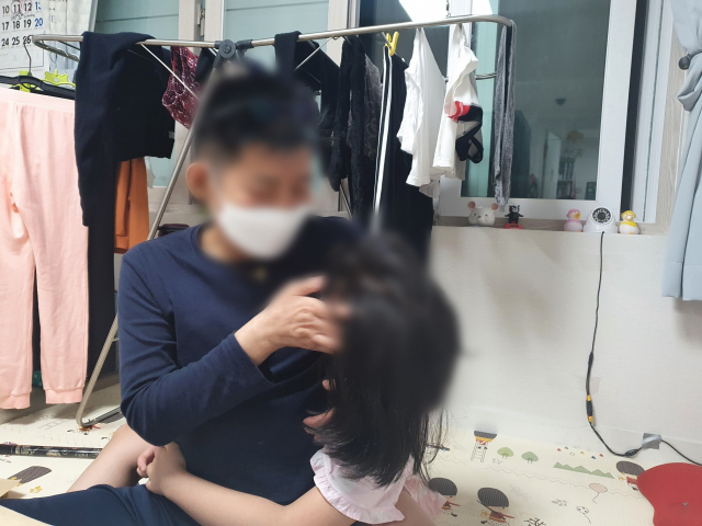 김홍태(가명·61) 씨가 딸 승희(가명·10) 양의 머리를 쓰다듬어 주고 있다. 배주현 기자