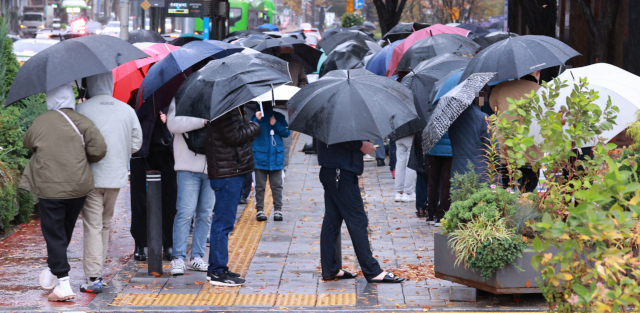 8일 오전 서울 송파구 보건소 코로나19 선별검사소에서 시민들이 검사를 받기 위해 우산을 쓴 채 차례를 기다리고 있다. 중앙방역대책본부는 이날 0시 기준으로 신규 확진자가 1천760명 늘어 누적 38만1천694명이라고 밝혔다. 전날보다 464명 감소하면서 지난 2일(1천589명) 이후 6일 만에 1천명대를 기록했다. 이날 신규 확진자 수는 주말 검사 건수가 감소한 영향을 받은 것으로 보인다. 연합뉴스