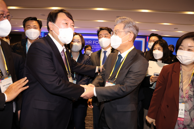 더불어민주당 이재명 대선 후보(오른쪽)와 국민의힘 윤석열 대선 후보가 10일 서울 광진구 그랜드워커힐서울에서 한국경제신문 주최로 열린 글로벌인재포럼2021 행사 VIP 간담회에서 악수하고 있다. 연합뉴스