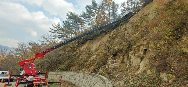 문경시가 동로면 생달리 도로 절개지 급경사지에 다채널 센서를 활용한 산사태 예측·경보와 원격 모니터링 시스템을 중장비로 설치하고 있는 장면. 문경시 제공