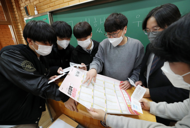 지난달 19일 대전시 대성고등학교 3학년 교실에서 학생들이 전날 치른 2022학년도 수능시험 가채점 점수를 토대로 지원 가능한 대학을 상담하고 있다. 연합뉴스