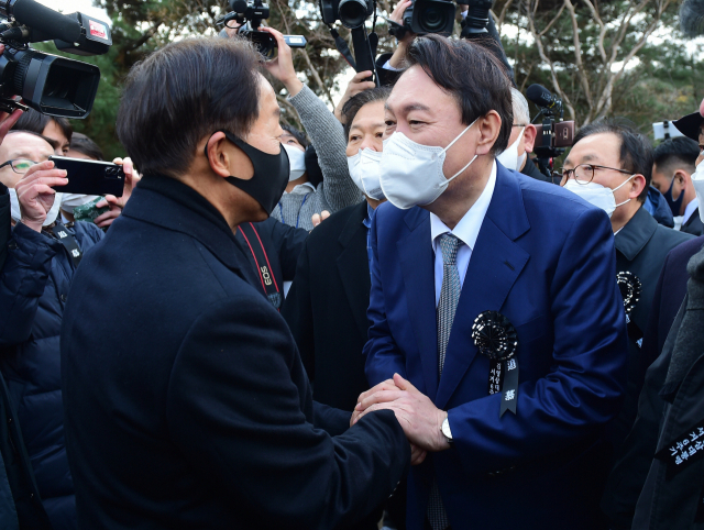 국민의힘 윤석열 대선 후보가 22일 오후 서울 동작구 국립서울현충원 내 김영삼 전 대통령 묘역에서 열린 6주기 추모식에서 차남인 김현철 김영삼민주센터 상임이사와 인사하고 있다. 연합뉴스