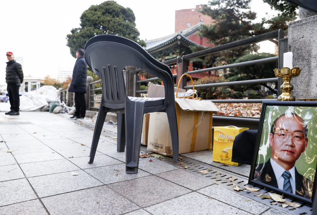 24일 오전 서울 종로구 보산각 앞에 철거된 후 남은 전두환 전 대통령 영정 사진이 놓여있다. 보수 성향 단체인 태극기혁명국민운동본부(국본)는 이날 심야 시간대 전 전 대통령 추모 분향소를 설치했다. 연합뉴스