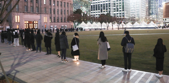 3일 저녁 서울광장 선별진료소에서 시민들이 검사를 기다리고 있다. 이날 정부는 코로나19 재확산에 따라 사적 모임 허용인원을 다시 줄이고 