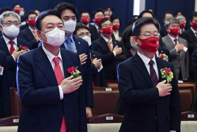 더불어민주당 이재명 대선 후보와 국민의힘 윤석열 대선 후보가 3일 오전 서울 여의도 한국거래소에서 열린 2022년 증권·파생상품시장 개장식에서 국기에 경례하고 있다. 연합뉴스