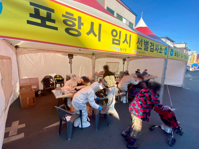 6일 경북 포항 한 전통시장 인근에 마련된 임시 선별검사소에서 상인이 신종 코로나바이러스 감염증(코로나19) 검사를 받고 있다. 이 시장에선 최근 코로나19 확진자가 10여 명 나왔다. 연합뉴스