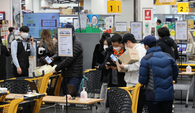 오는 10일부터 백화점, 대형마트에 가려면 코로나19 백신 접종증명서나 48시간 내 발급받은 PCR(유전자증폭검사) 음성확인서를 내야 한다. 9일 오후 경기도 고양시 한 대형마트에서 시민들이 QR 체크인을 하고 있다. 연합뉴스