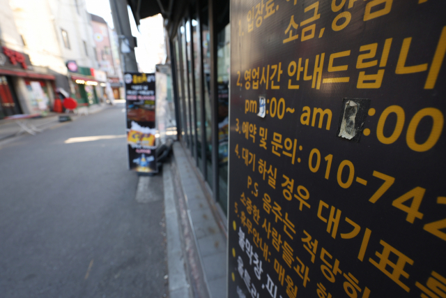 14일 오후 서울 건국대학교 인근 술집에 코로나19 확산 이전에 붙여놓은 듯한 영업시간 안내문이 내걸려 있다. 정부는 오는 17일부터 내달 6일까지 3주간 사적모임 인원을 6인으로, 식당·카페 등의 영업시간은 오후 9시로 제한하는 사회적 거리두기를 적용하기로 했다. 하지만 자영업자 단체들은 