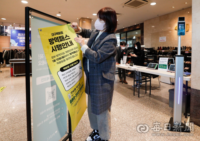 17일 오후 대구 중구 대백프라자 입구에서 직원이 영업시간이 종료되자 방역패스 안내문을 떼어내고 있다. 18일부터는 백화점·대형마트 등 대규모 점포를 비롯해 독서실·스터디카페, 도서관, 박물관·미술관·과학관, 학원, 영화관·공연장 등 6종 시설의 방역패스가 해제된다. 우태욱 기자 woo@imaeil.com