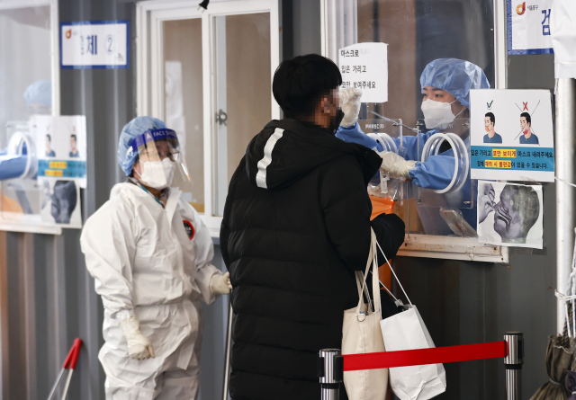 2일 오전 서울 중구 서울역 광장에 마련된 코로나19 임시선별검사소에서 시민이 검사를 받고 있다. 중앙방역대책본부는 이날 0시 기준으로 코로나19 신규 확진자가 3천833명 늘어 누적 확진자 수가 63만9천83명이라고 밝혔다. 연합뉴스