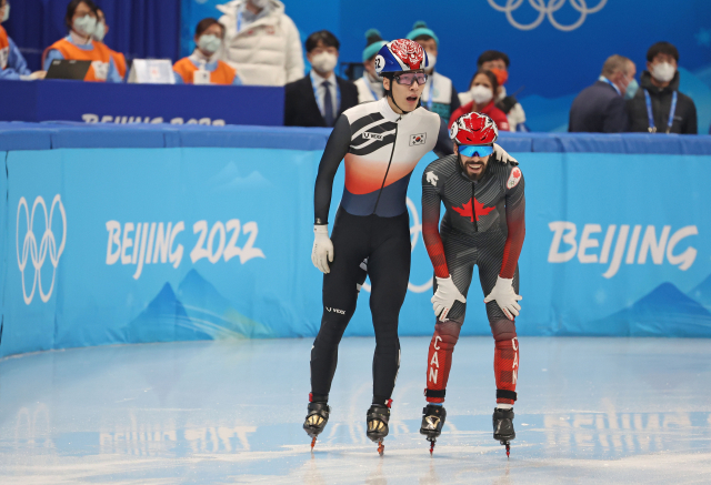 대한민국 쇼트트랙 대표팀 황대헌이 13일 오후 중국 베이징 캐피털 실내 경기장에서 열린 2022 베이징 동계올림픽 쇼트트랙 남자 500m 준결승 2조 경기를 마친 뒤 경기 도중 충돌한 캐나다 스티븐 뒤부아와 대화를 나누고 있다. 연합뉴스