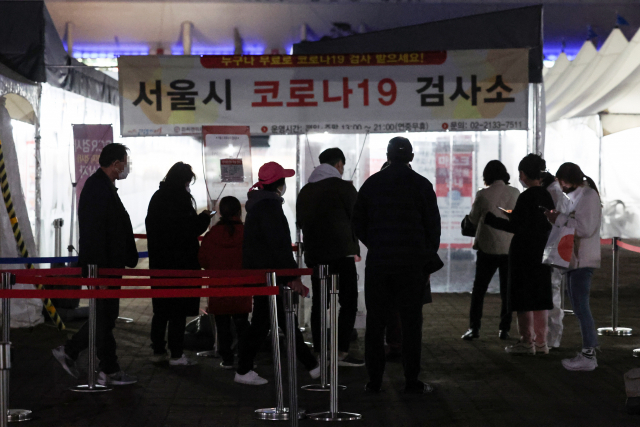 22일 오후 서울 마포구 월드컵공원 평화광장 임시선별검사소에서 피검자들이 줄을 서 있다. 이날 오후 6시까지 선별진료소 PCR 검사나 병·의원 신속항원검사를 통해 전국에서 33만7천27명의 확진자가 나오면서 누적 확진자 수가 1천만명을 돌파했다. 연합뉴스