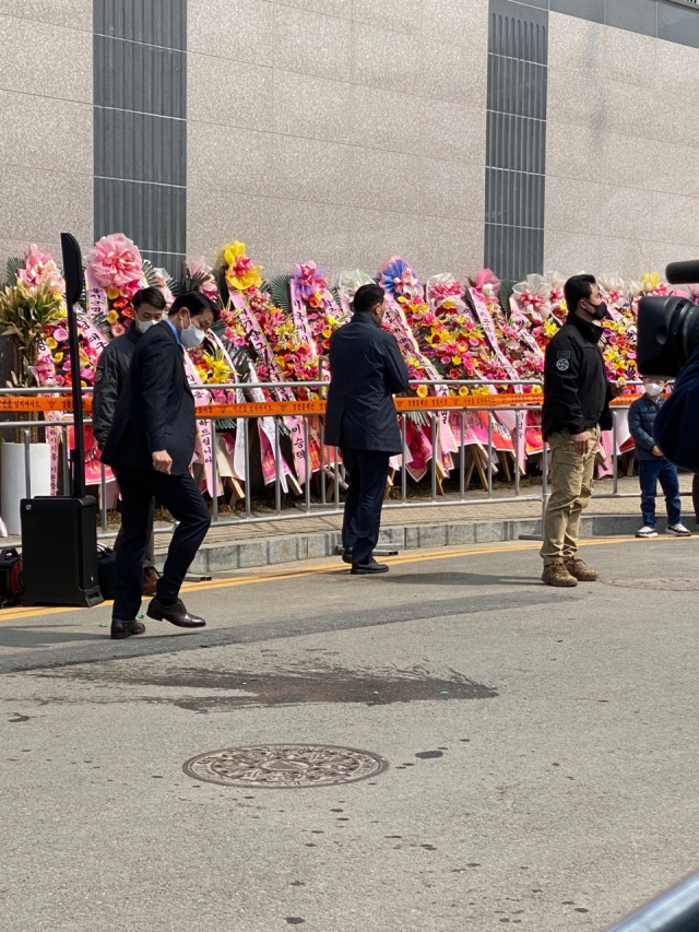 박근혜 전 대통령을 향해 누군가 소주병을 던졌다. 바닥에 깨진 소주병 잔해를 경호원이 치우고 있다. 사진=이찬민 기자