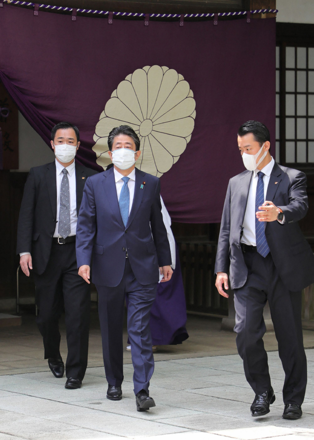 아베 신조 전 일본 총리(가운데)가 21일 일제의 태평양전쟁을 이끌었던 A급 전범들이 합사된 야스쿠니신사를 직접 참배한 뒤 걸어 나가고 있다. 아베는 총리 재임 중에는 한국과 중국 등 주변국의 반발을 고려해 야스쿠니신사 직접 참배를 자제했으나 재작년 9월 퇴임 이후로는 춘계·추계 예대제(큰제사)와 태평양전쟁 종전일(8월 15일)에 맞춰 야스쿠니신사를 찾고 있다. 연합뉴스