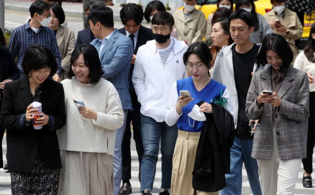 실외 마스크 의무착용 해제 첫날인 2일 광주 북구청 앞에서 점심시간을 맞은 공무원들이 마스크를 벗고 길을 건너고 있다. 연합뉴스