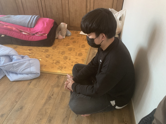 이현우(가명·23) 씨가 어머니 없는 텅 빈 방안에 홀로 앉아 있다. 김세연 기자