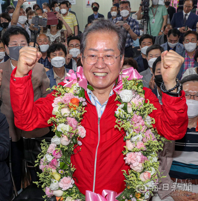 제8회 전국동시지방선거일인 1일 오후 국민의힘 홍준표 대구시장 후보가 대구 중구 삼덕동 마련된 선거사무소에서 당선이 확실시 되자 꽃다발을 목에 걸고 기념 촬영을 하고 있다. 안성완 기자 asw0727@imaeil.com