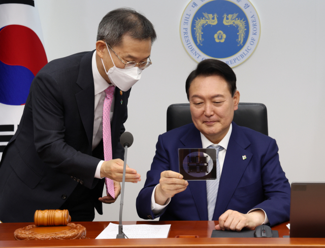 윤석열 대통령이 지난해 6월 서울 용산 대통령실 청사에서 열린 국무회의에서 이종호 과학기술정보통신부 장관과 반도체 포토마스크를 살펴보고 있다. 연합뉴스