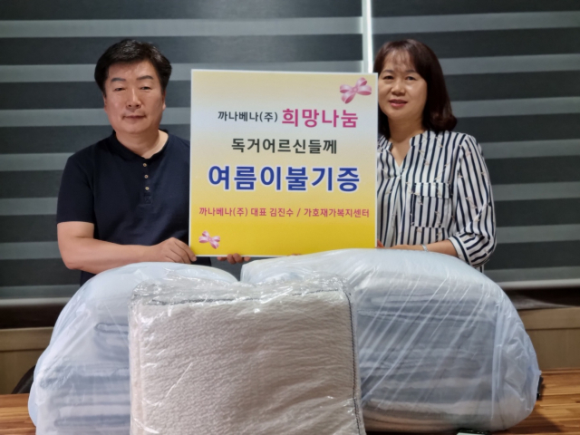 13일 까나베나㈜ 김진수(오른쪽) 대표가 가호재가복지센터 정미란 센터장에게 여름 이불 70채를 기탁하고 있다.