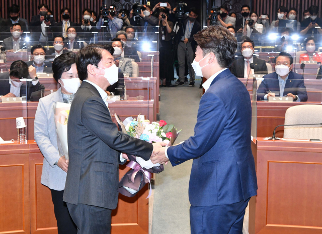 국민의힘 이준석 대표가 14일 서울 여의도 국회에서 열린 국민의힘 의원총회에서 안철수 의원에게 꽃다발을 전달하고 있다. 연합뉴스