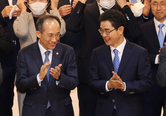 추경호 경제부총리 겸 기획재정부 장관(왼쪽)과 김창기 국세청장이 22일 오전 세종시 정부세종2청사 국세청 대강당에서 열린 전국 세무관서장 회의에서 기념촬영을 하며 박수치고 있다. 연합뉴스