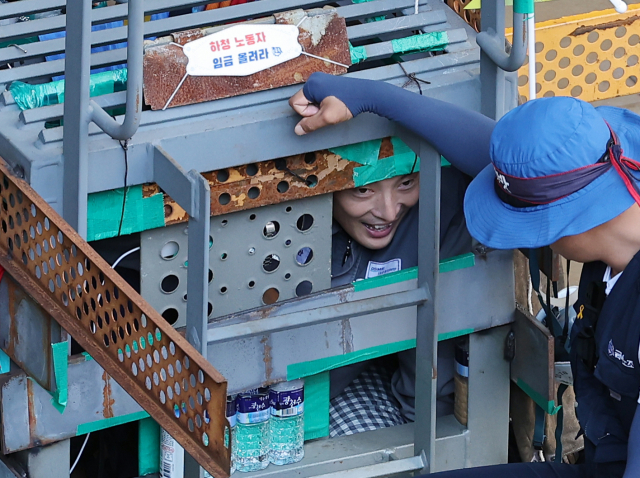 대우조선해양 하청노조 파업 51일째인 22일 오전 경남 거제시 대우조선해양 옥포조선소 1독의 가로, 세로, 높이 각 1ｍ 철 구조물에서 31일째 농성을 이어가고 있는 유최안 금속노조 거제통영고성 조선하청지회 부지회장이 관계자와 이야기를 나누고 있다. 연합뉴스